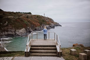 바다가 내려다 보이는 계단��에 서있는 여자