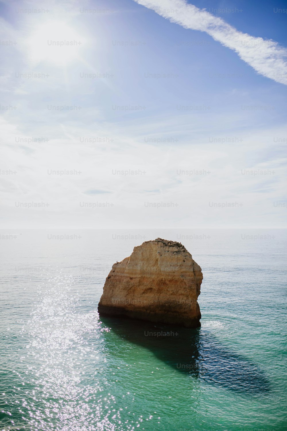 uma grande rocha saindo do oceano