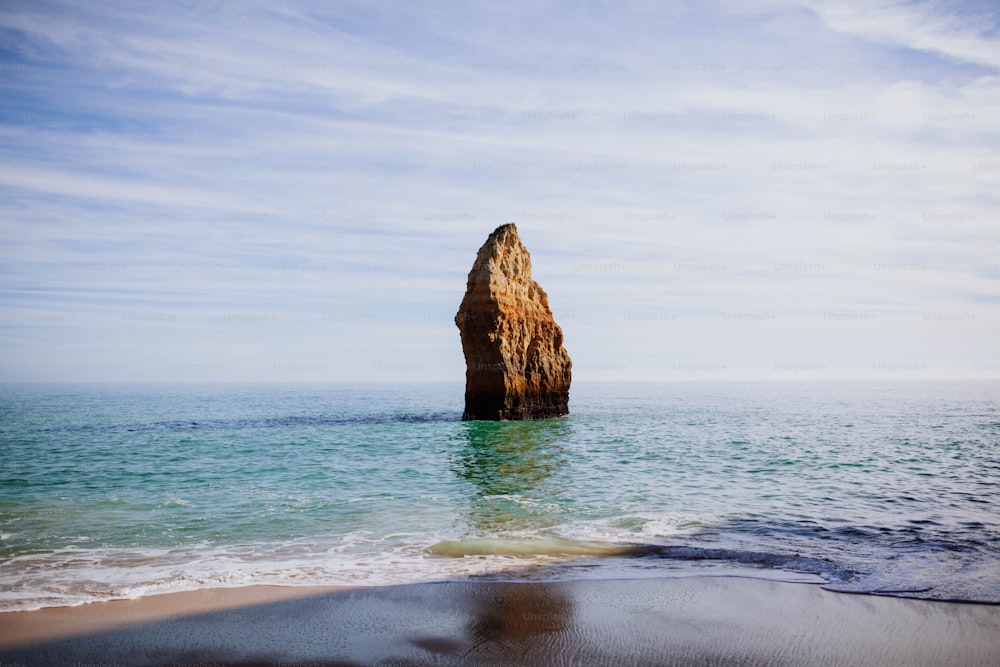 a large rock sticking out of the ocean