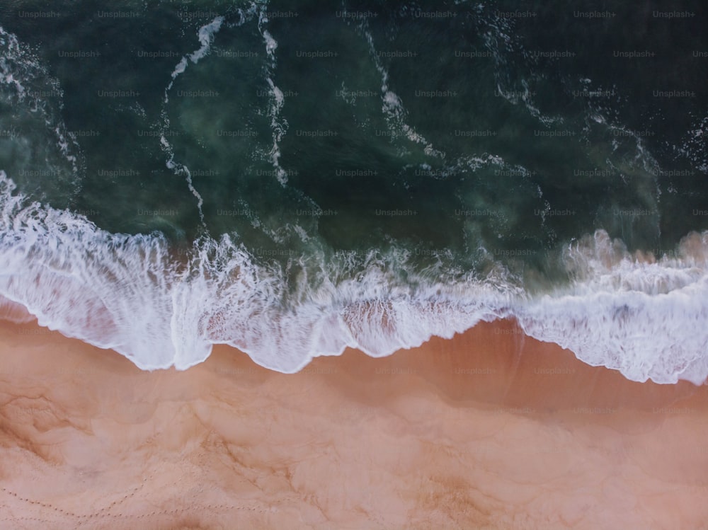 Una vista aérea de una playa de arena con olas