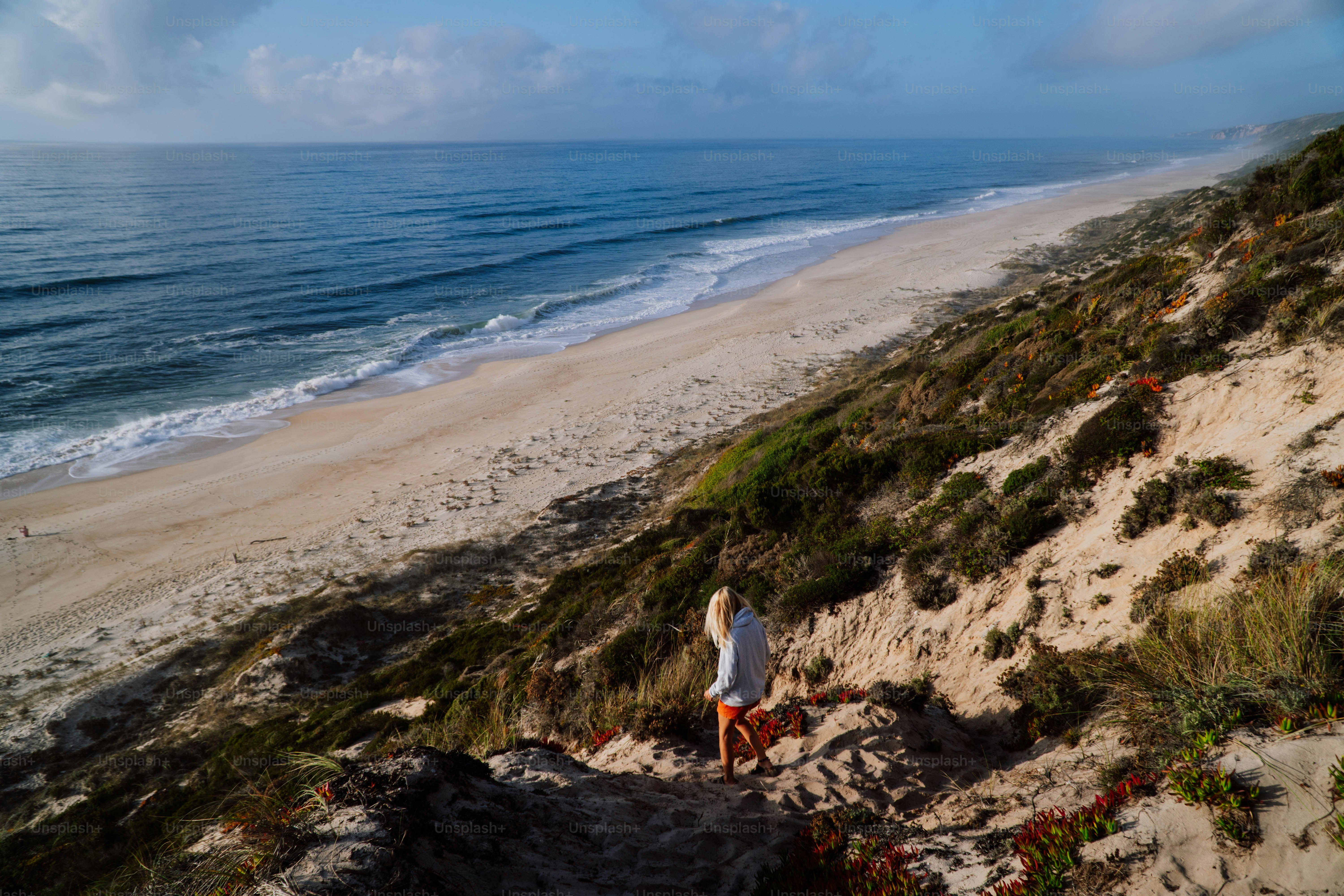 a person standing on a beach next to the ocean