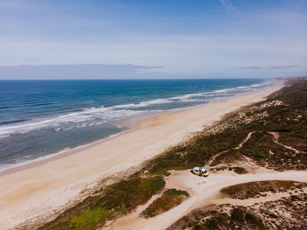 uma vista aérea de uma praia de areia e oceano