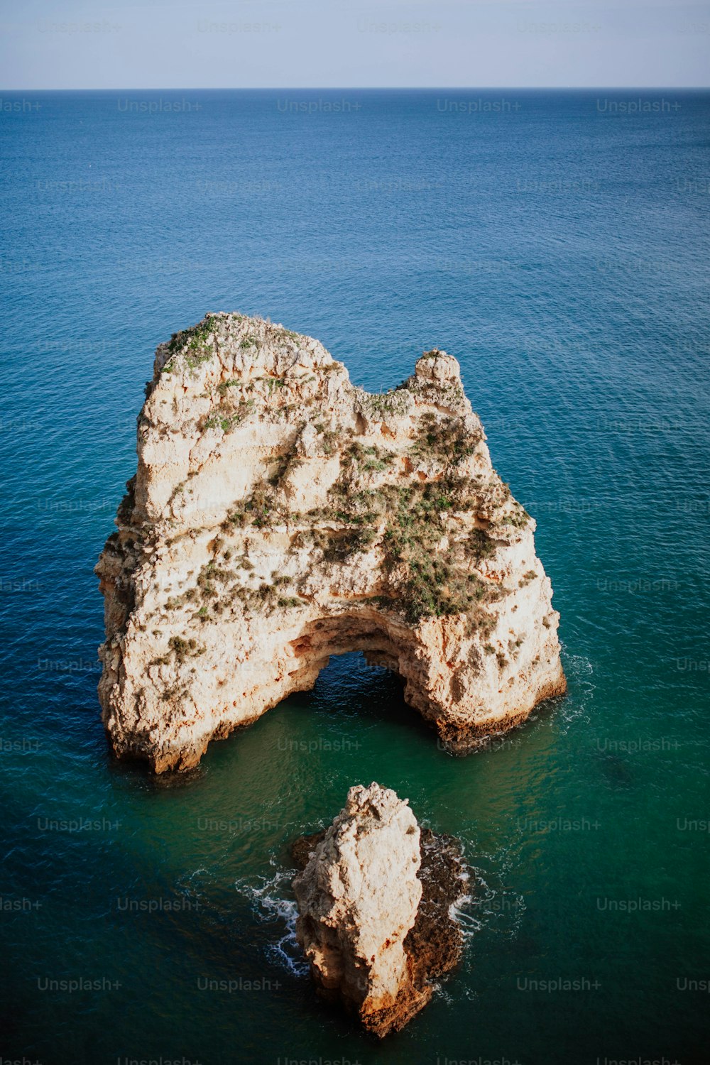 a rock formation in the middle of a body of water