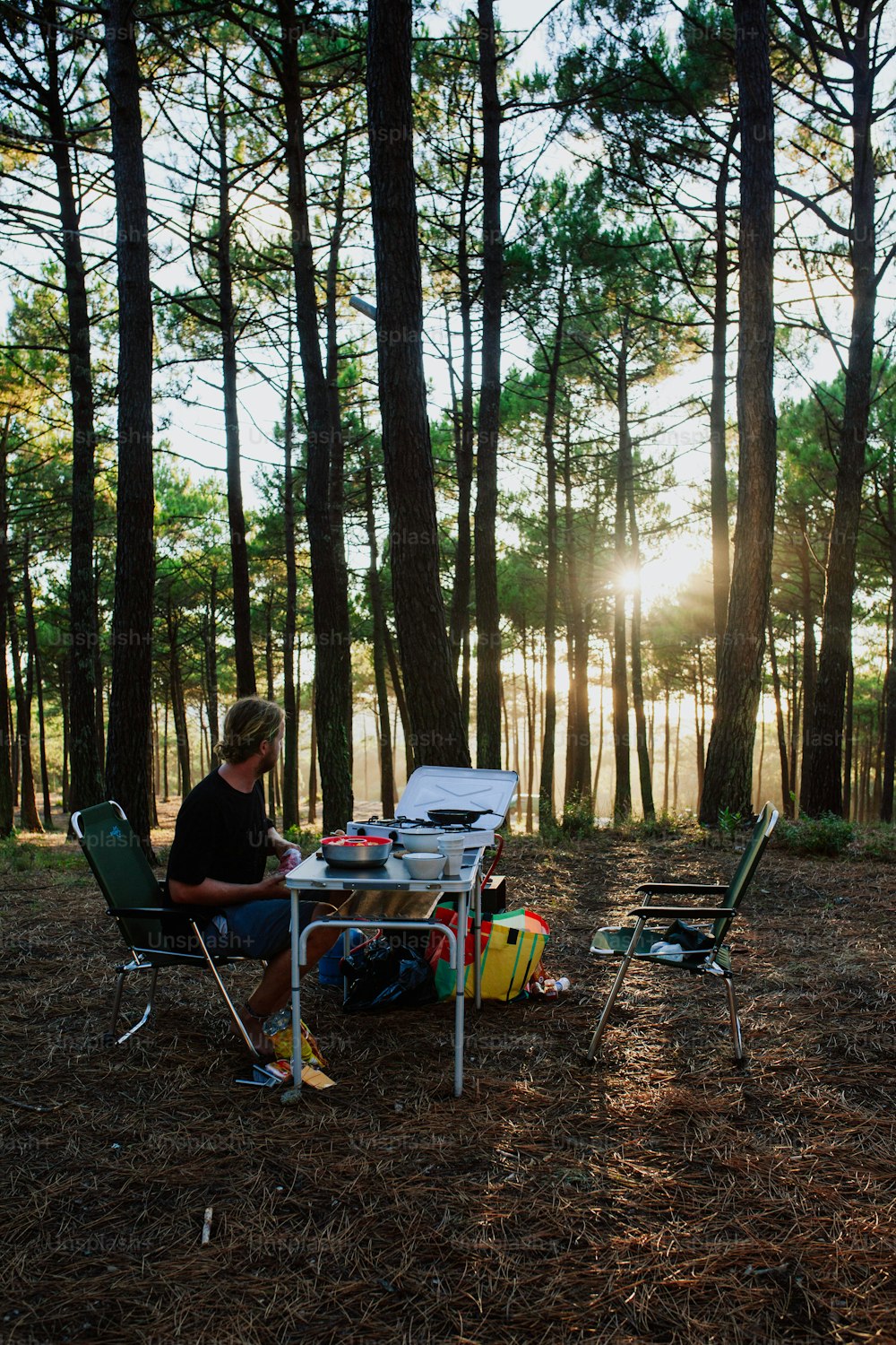 a person sitting at a table in the woods