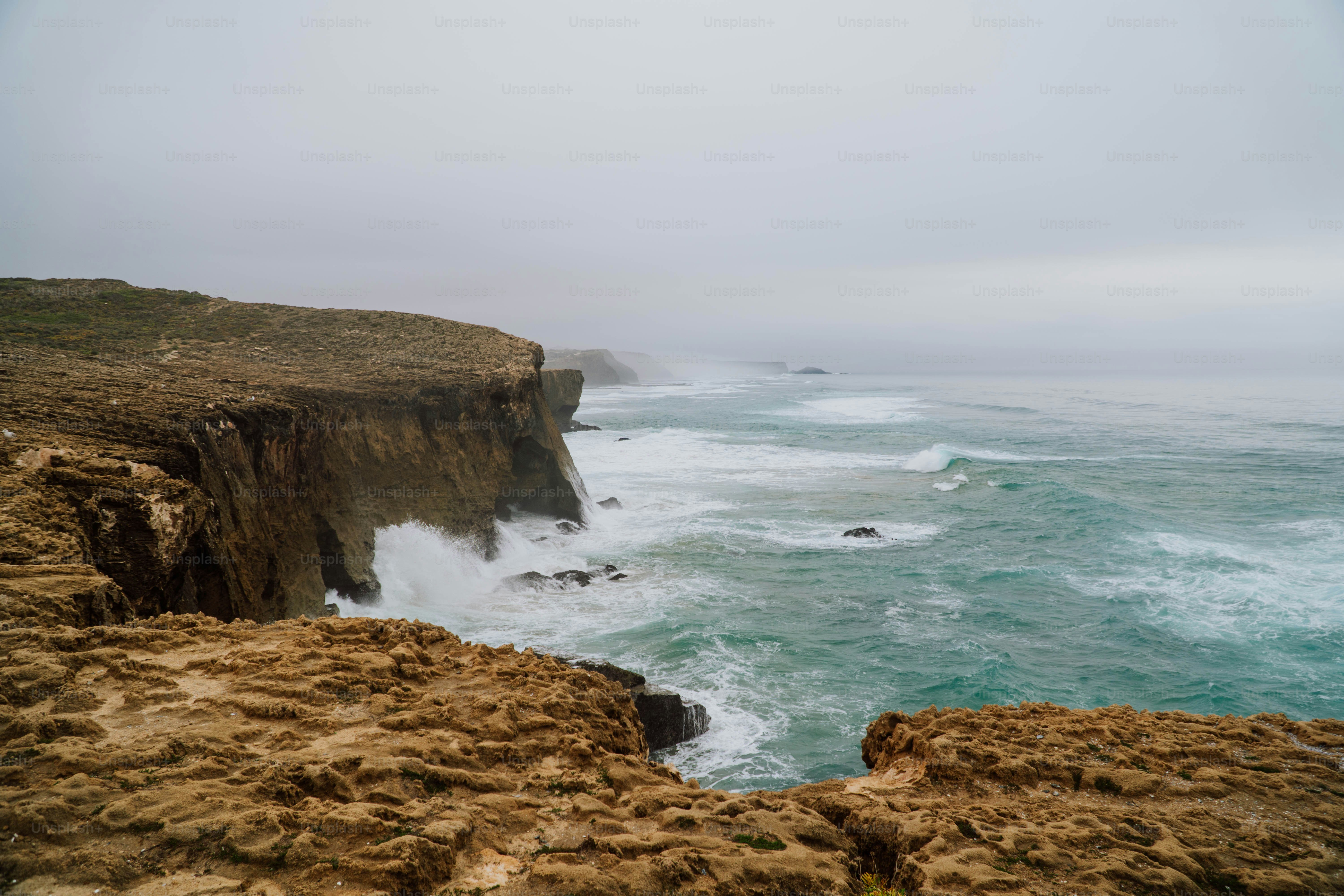 a large body of water next to a rocky cliff