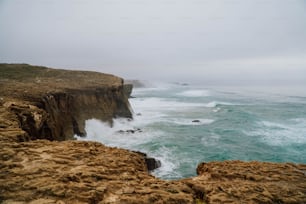 a large body of water next to a rocky cliff