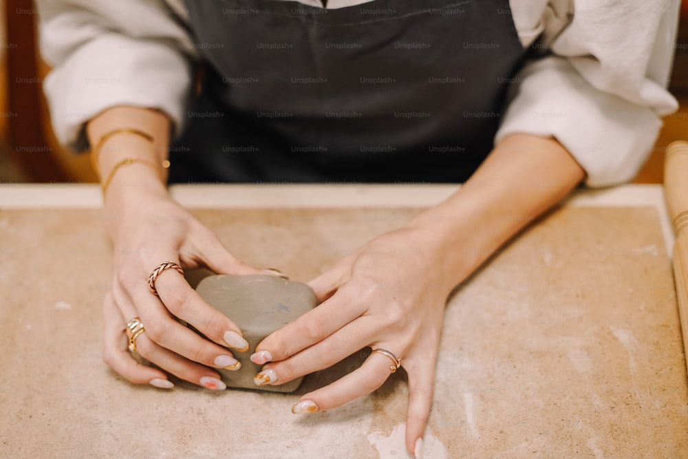 a woman in an apron is holding a stone