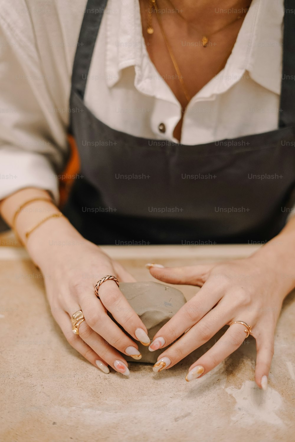 Eine Frau in einer Schürze hält einen Donut in der Hand