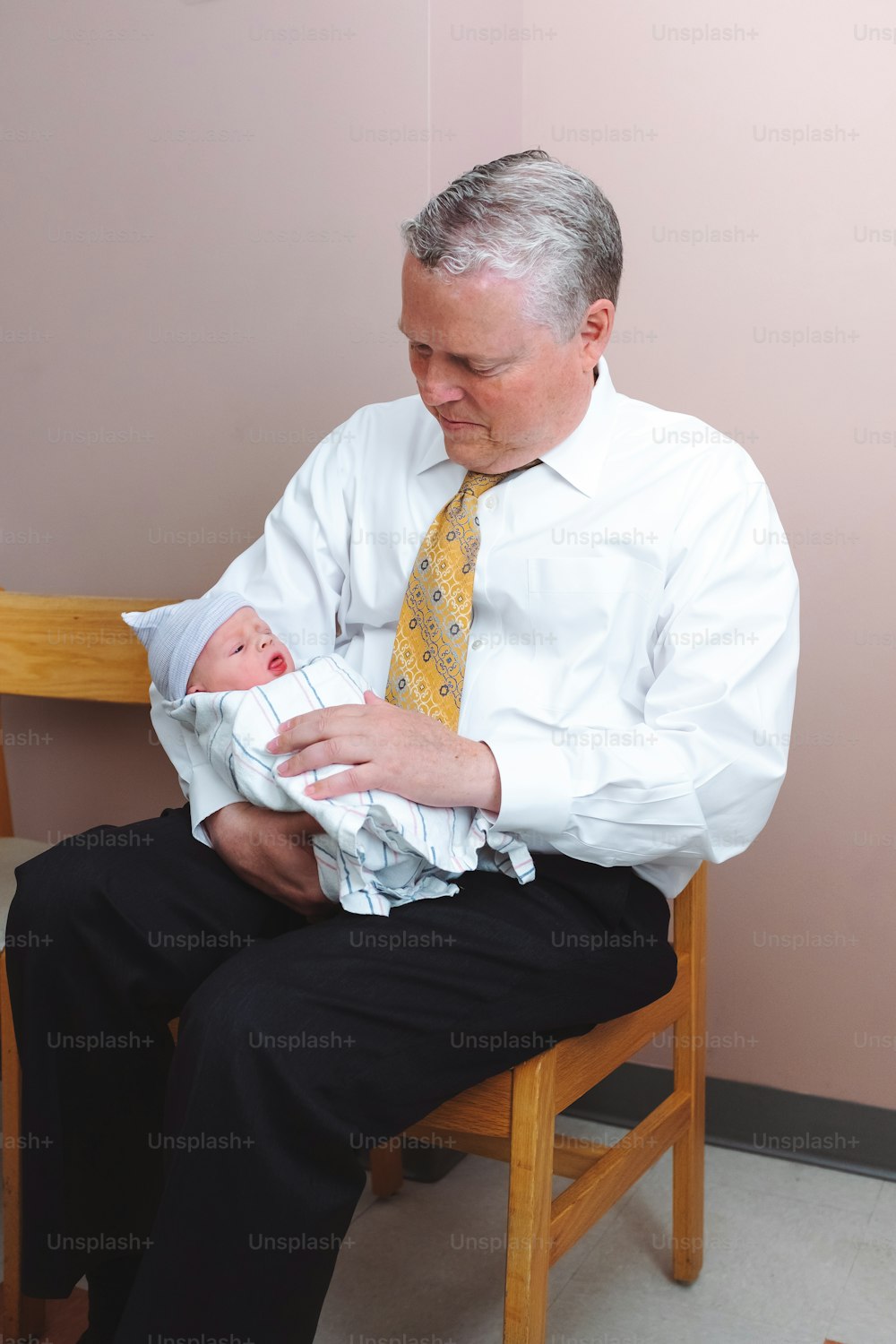 Un hombre con camisa blanca y corbata sosteniendo a un bebé