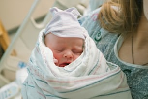 毛布に包まれた赤ん坊を抱く女性