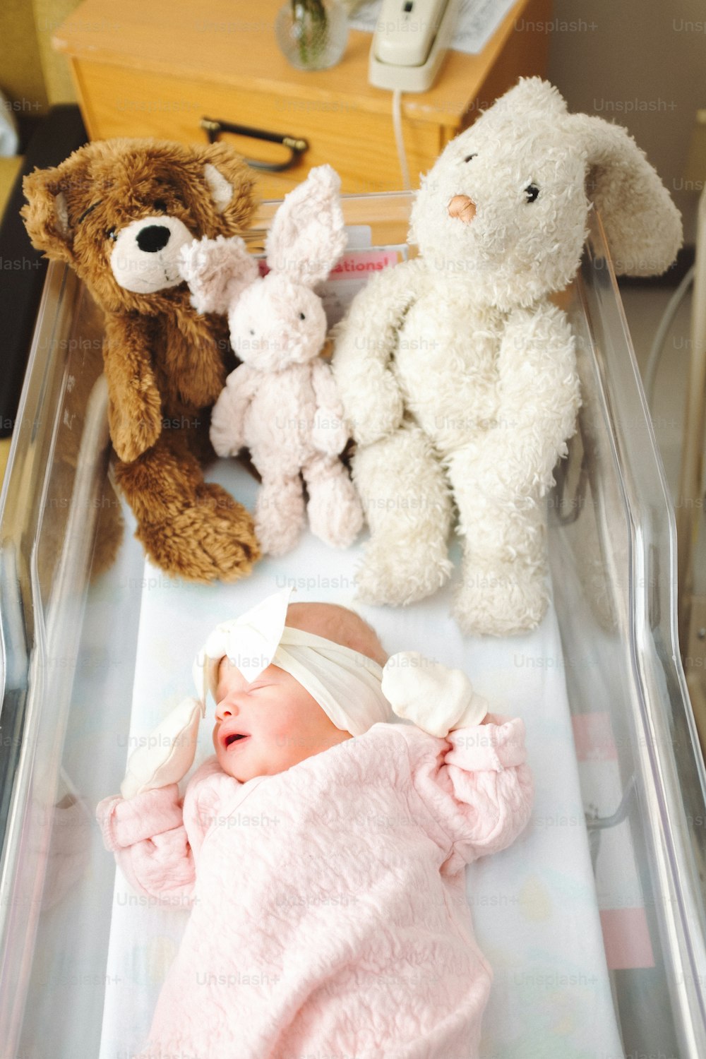 a baby in a crib with stuffed animals