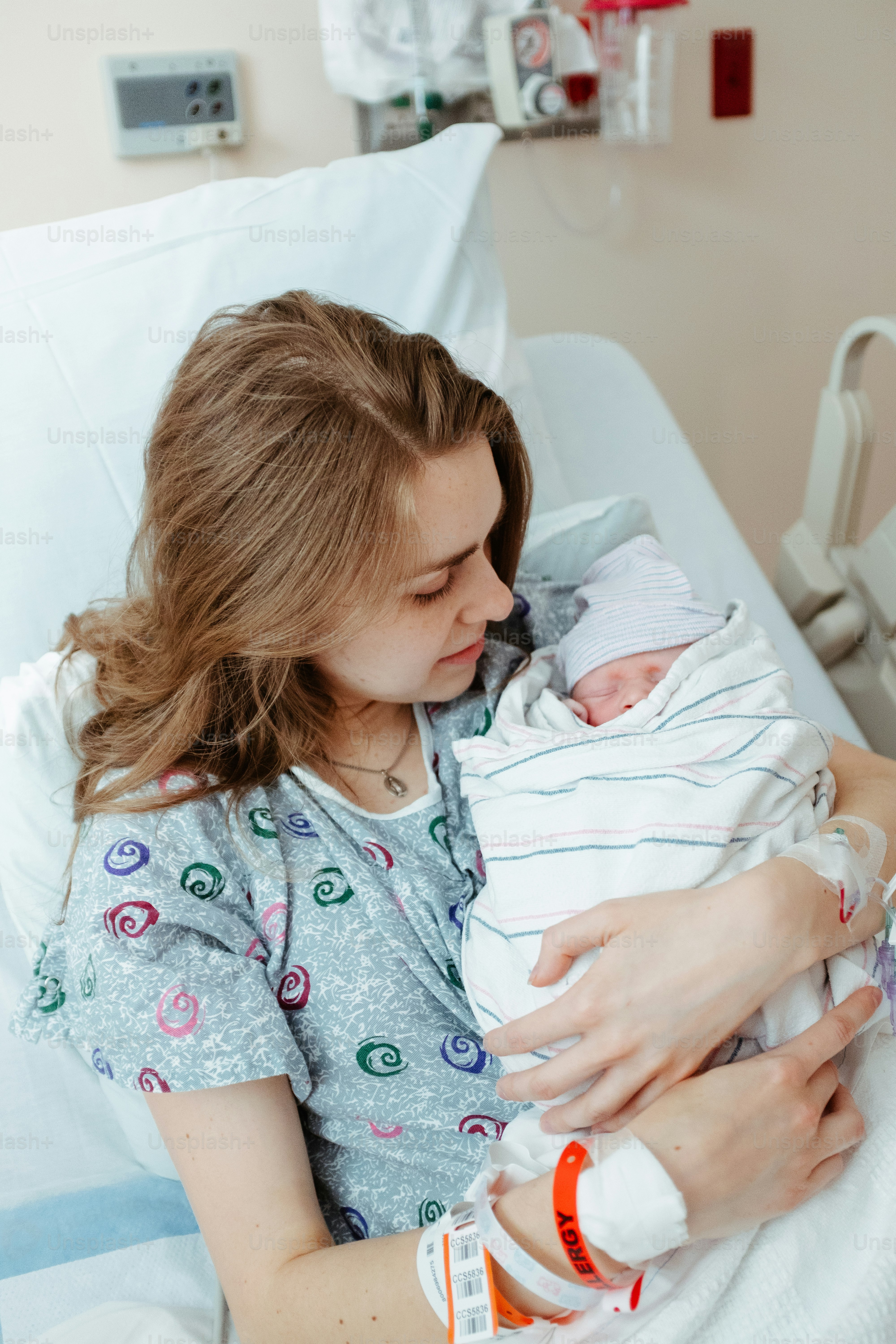 a woman holding a baby in a hospital bed