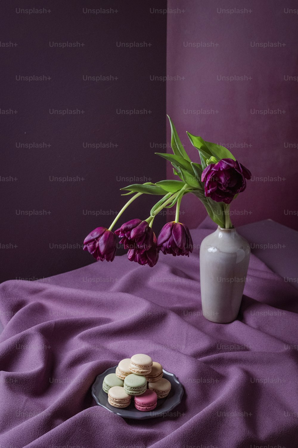 a plate of macaroons and a vase of flowers