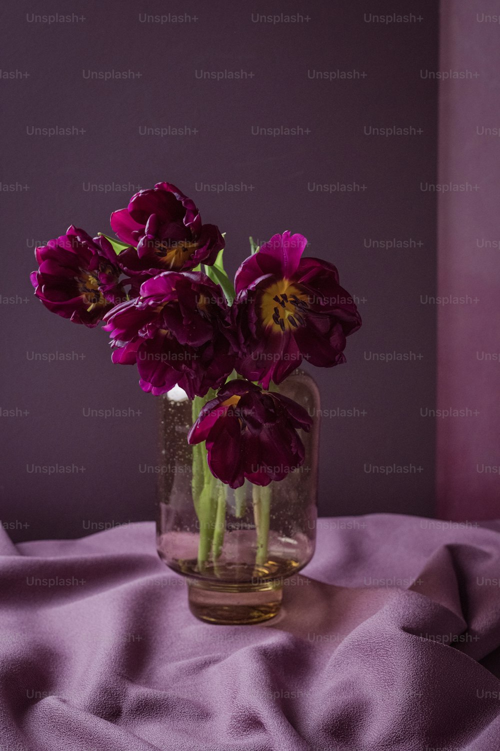 um vaso cheio de flores roxas em cima de uma mesa