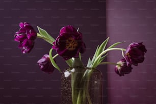 a vase filled with purple flowers on top of a table