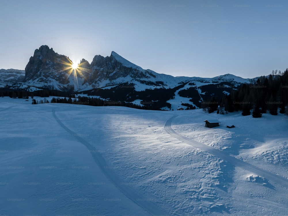 the sun is shining over a snowy mountain