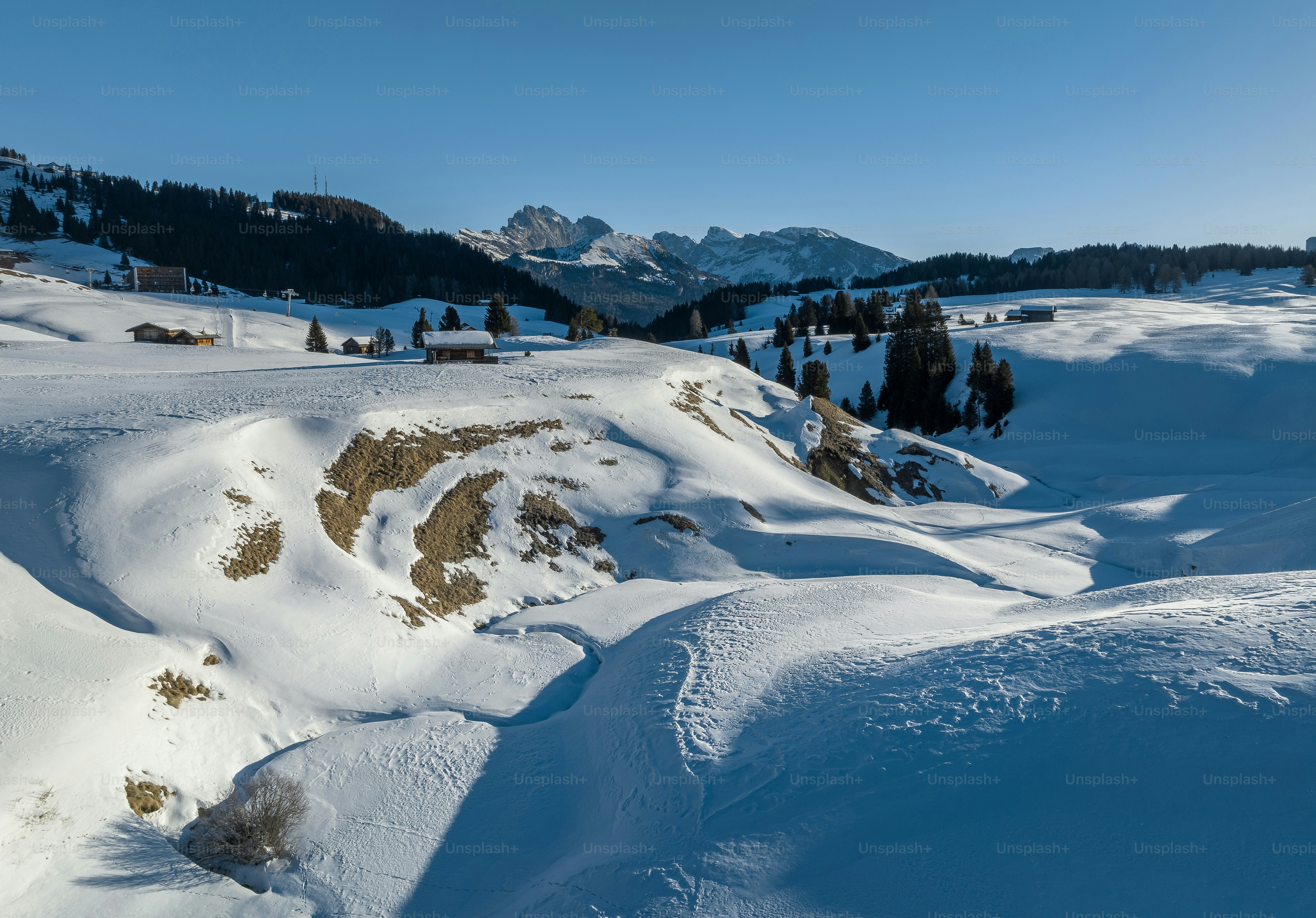 A mountain covered in snow with trees in the background photo – Italy ...