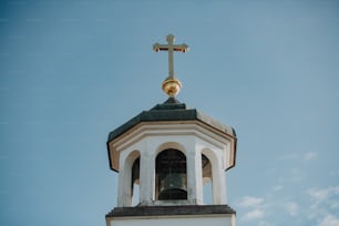 uma torre sineira da igreja com uma cruz no topo