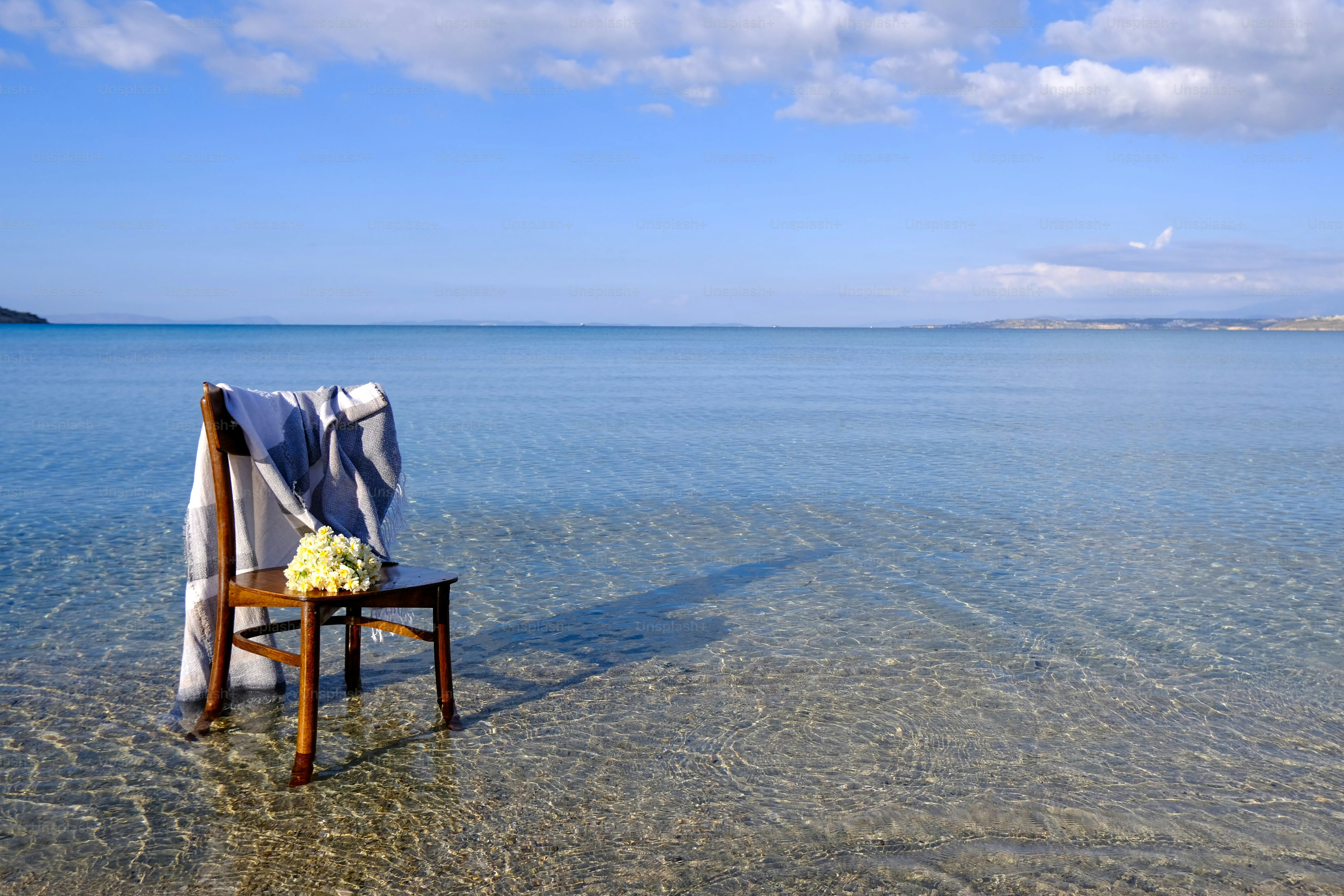 a chair with a blanket on it in the water