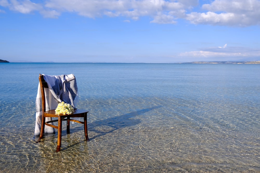a chair with a blanket on it in the water
