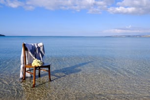 a chair with a blanket on it in the water