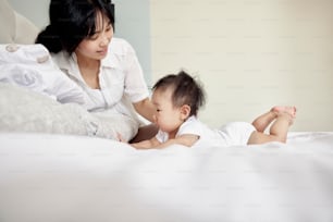 a woman and a baby laying on a bed
