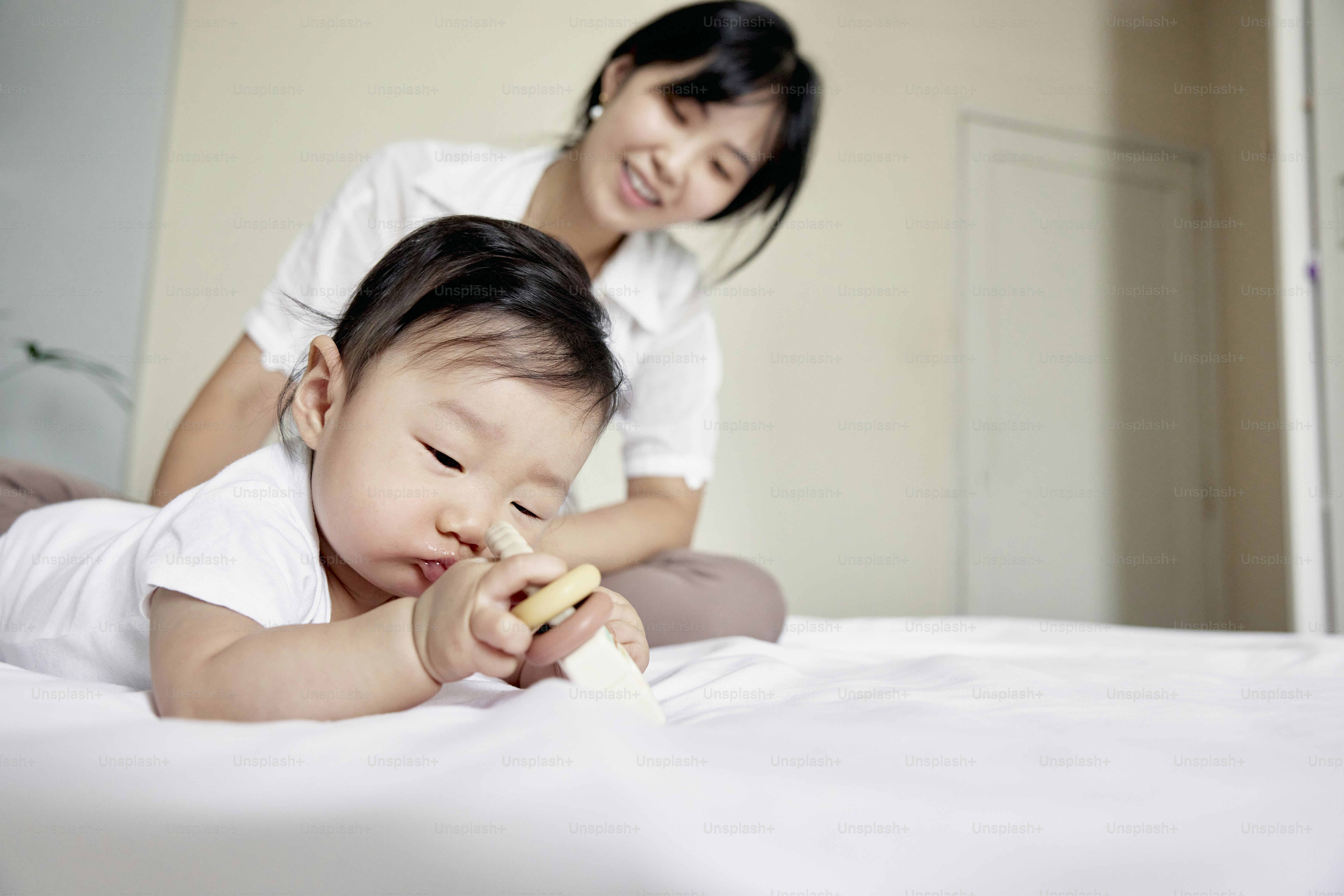 a woman and a baby laying on a bed