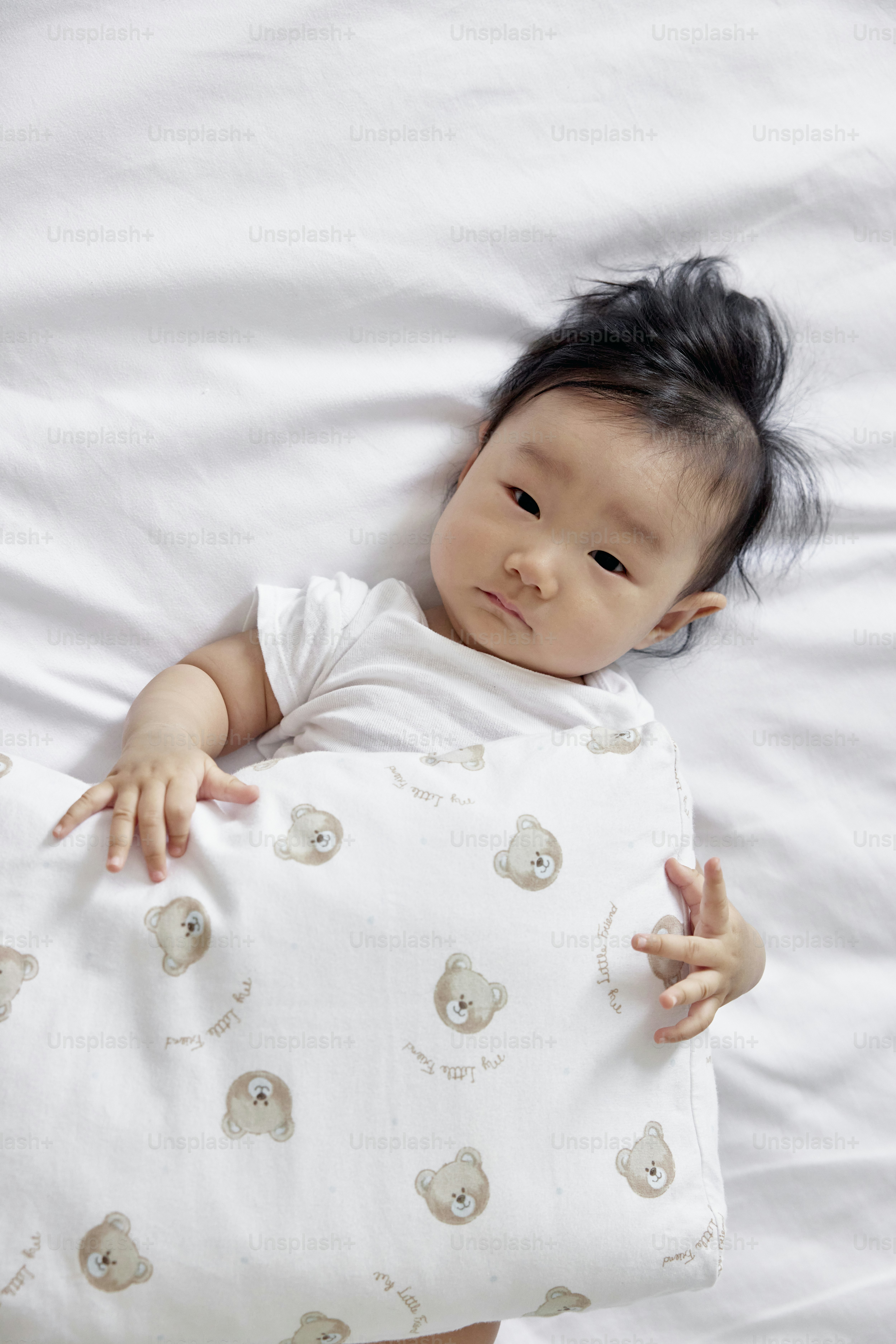 a baby laying on a bed with a pillow
