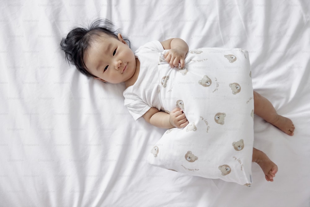 a baby is laying on a white sheet