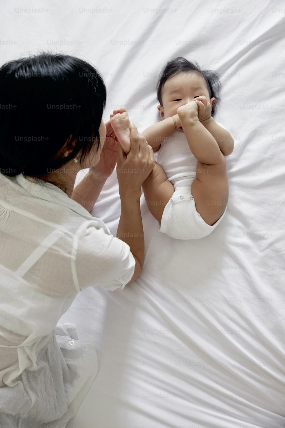 Una mujer acostada en una cama sosteniendo a un bebé