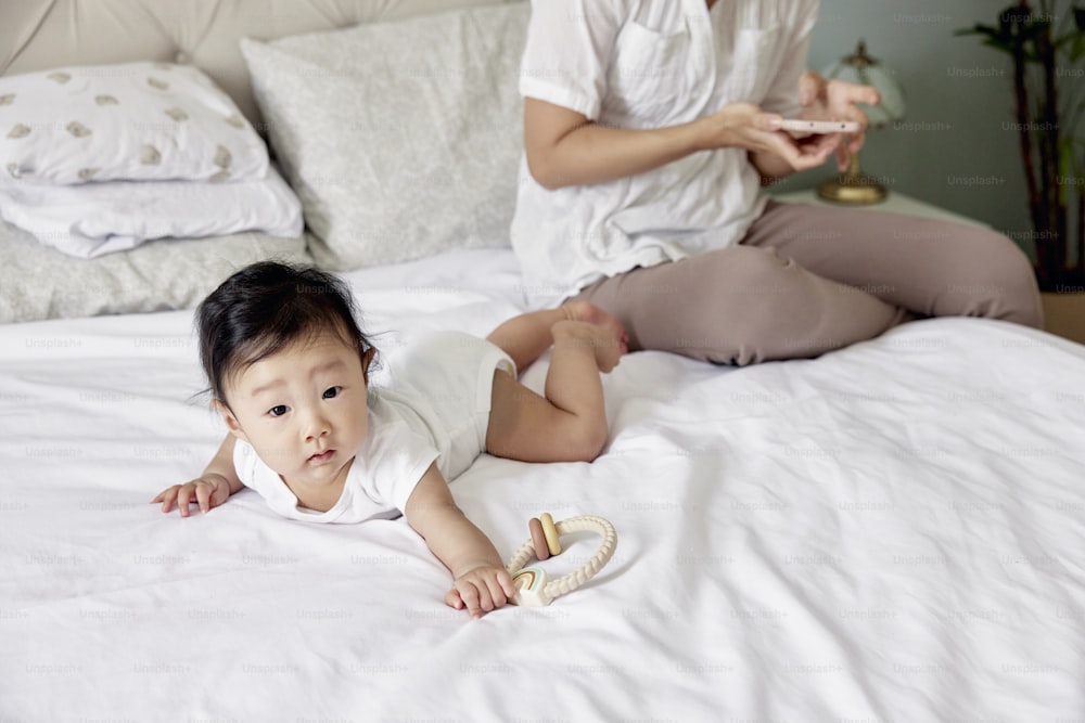 a baby laying on a bed next to a woman