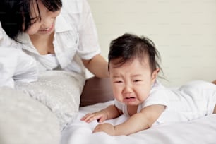 a baby crying while being held by a woman