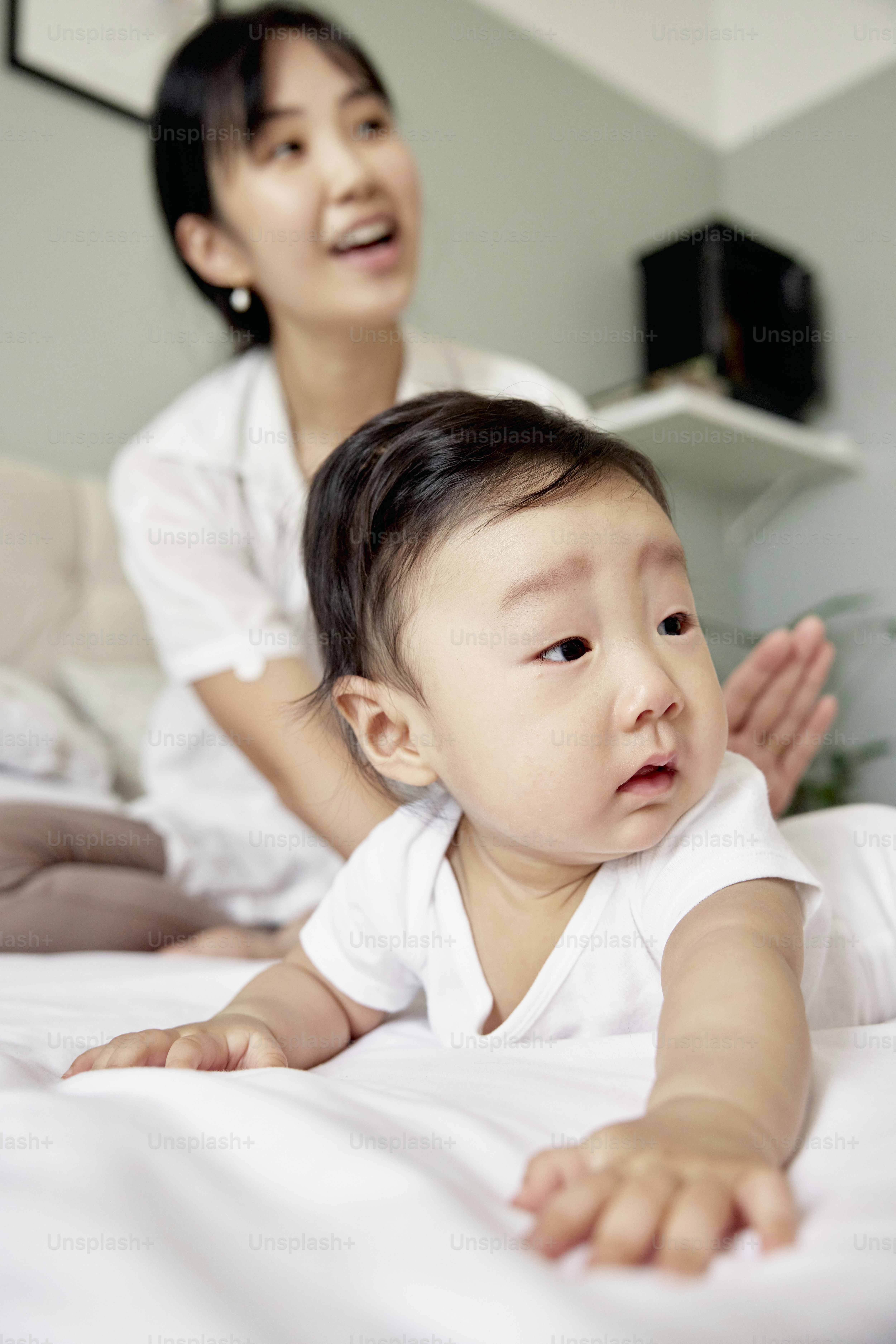 a baby laying on a bed next to a woman