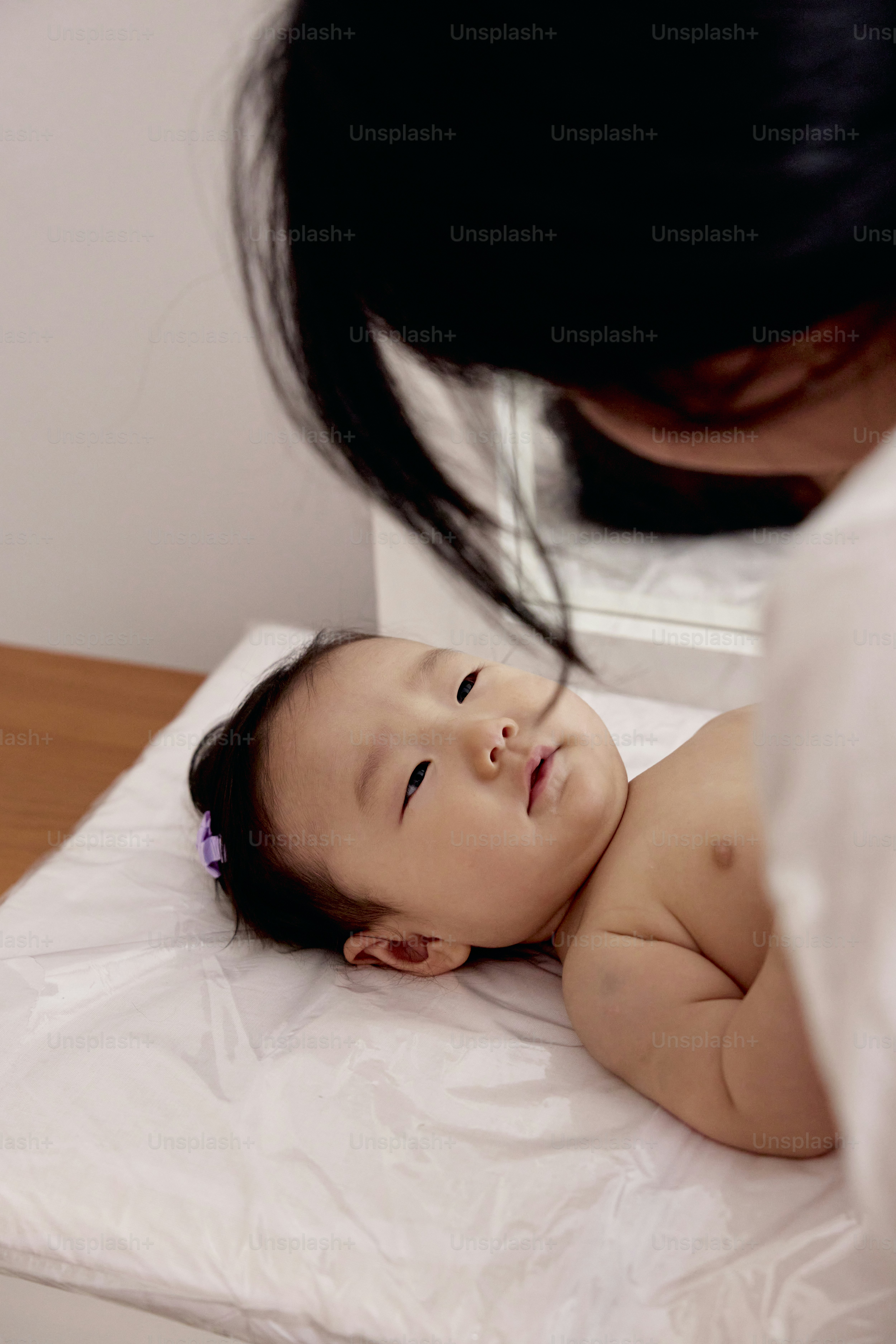 a baby laying on top of a bed next to a woman