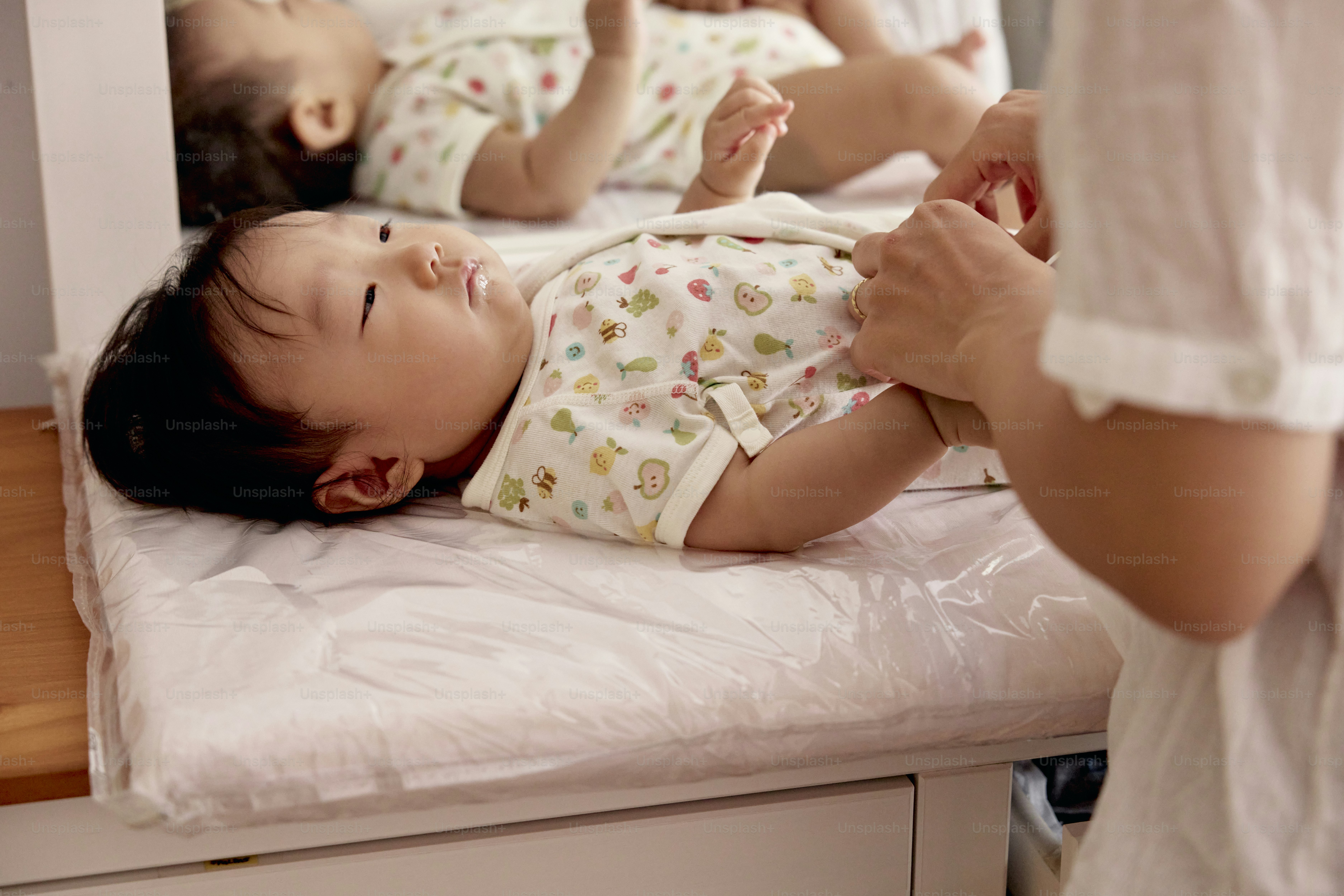 a baby laying on top of a bed next to a woman
