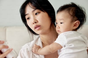 a woman holding a baby and playing a video game