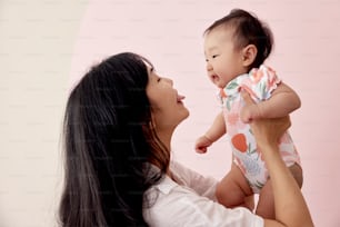 a woman holding a baby up to her face