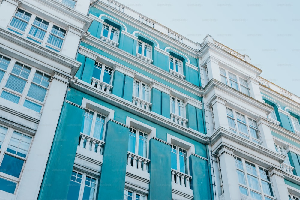ein blau-weißes Gebäude mit Fenstern und Balkonen
