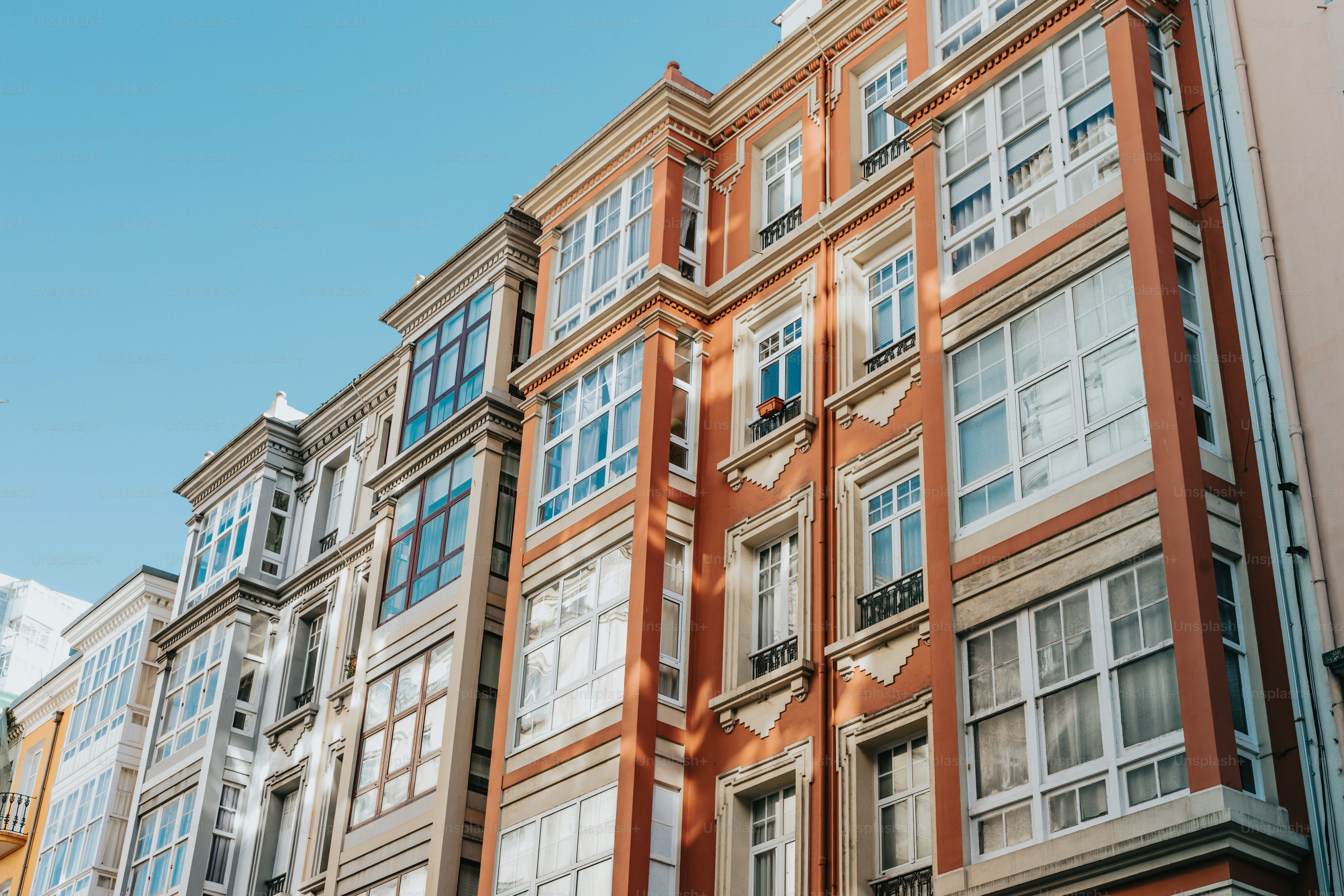 a tall building with lots of windows next to other buildings