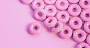 a pile of pink donuts on a pink background