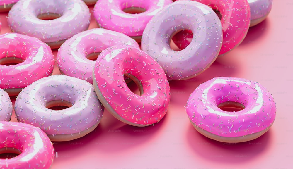 um grupo de donuts com cobertura rosa e polvilhos