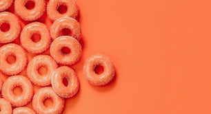 ein Haufen glasierter Donuts auf orangefarbenem Hintergrund