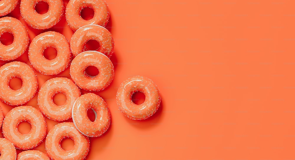 a pile of glazed donuts on an orange background