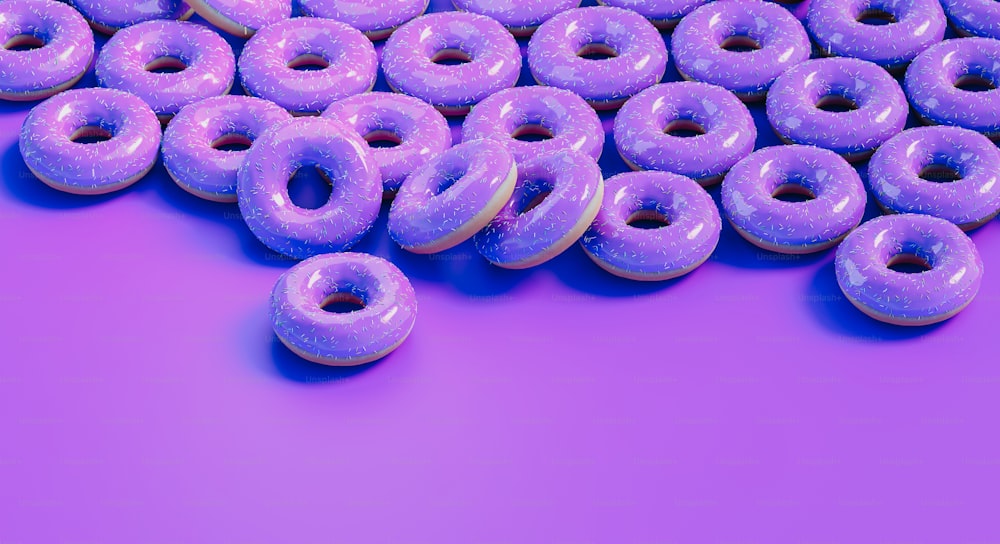 a pile of purple donuts sitting on top of a purple surface