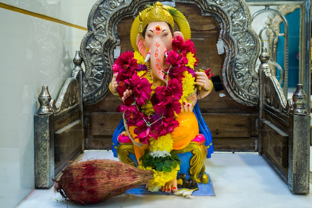 a statue of an elephant with flowers around it