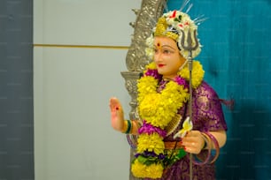 a statue of a woman in a purple and yellow outfit