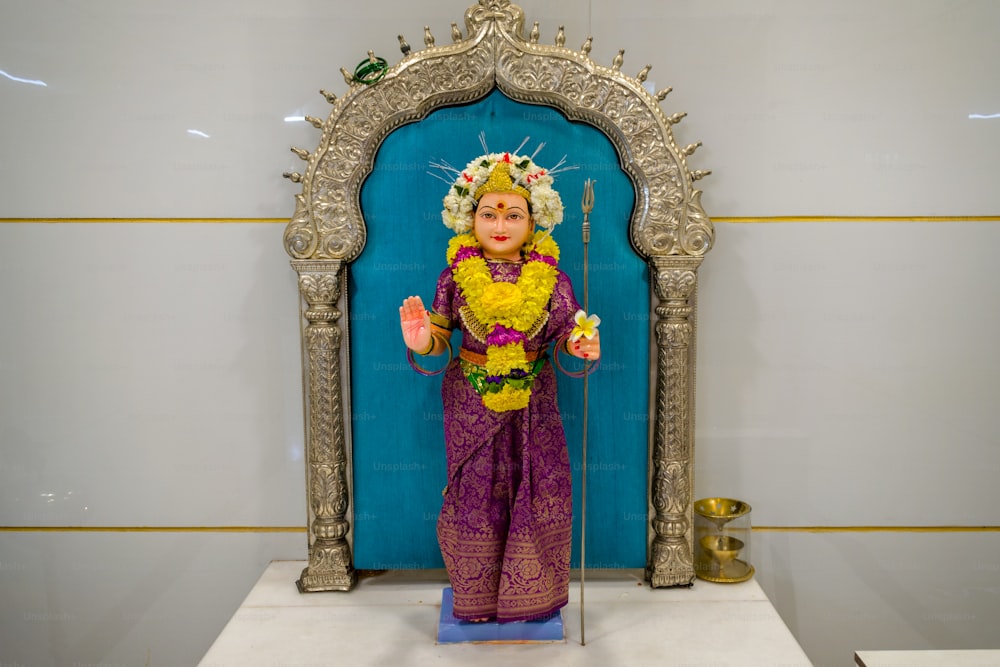 Eine Statue einer Frau in lila Outfit
