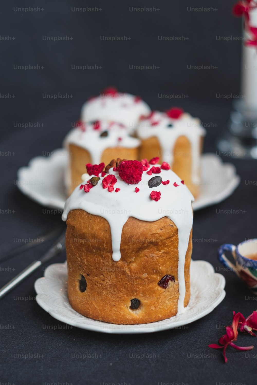 Un bundt cake con glaseado blanco y frambuesas por encima