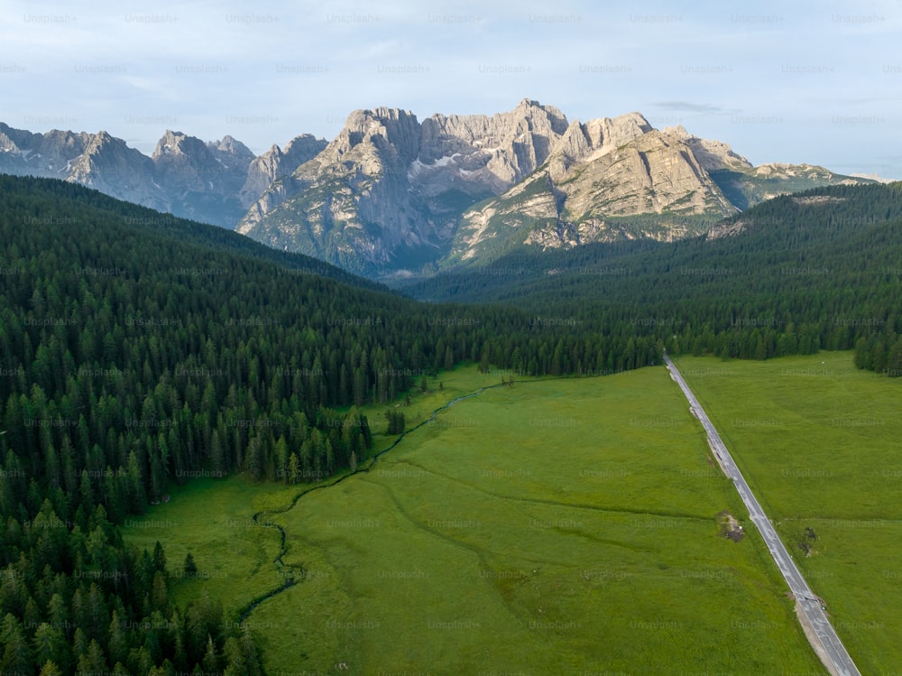 an aerial view of a mountain valley with a road running through it