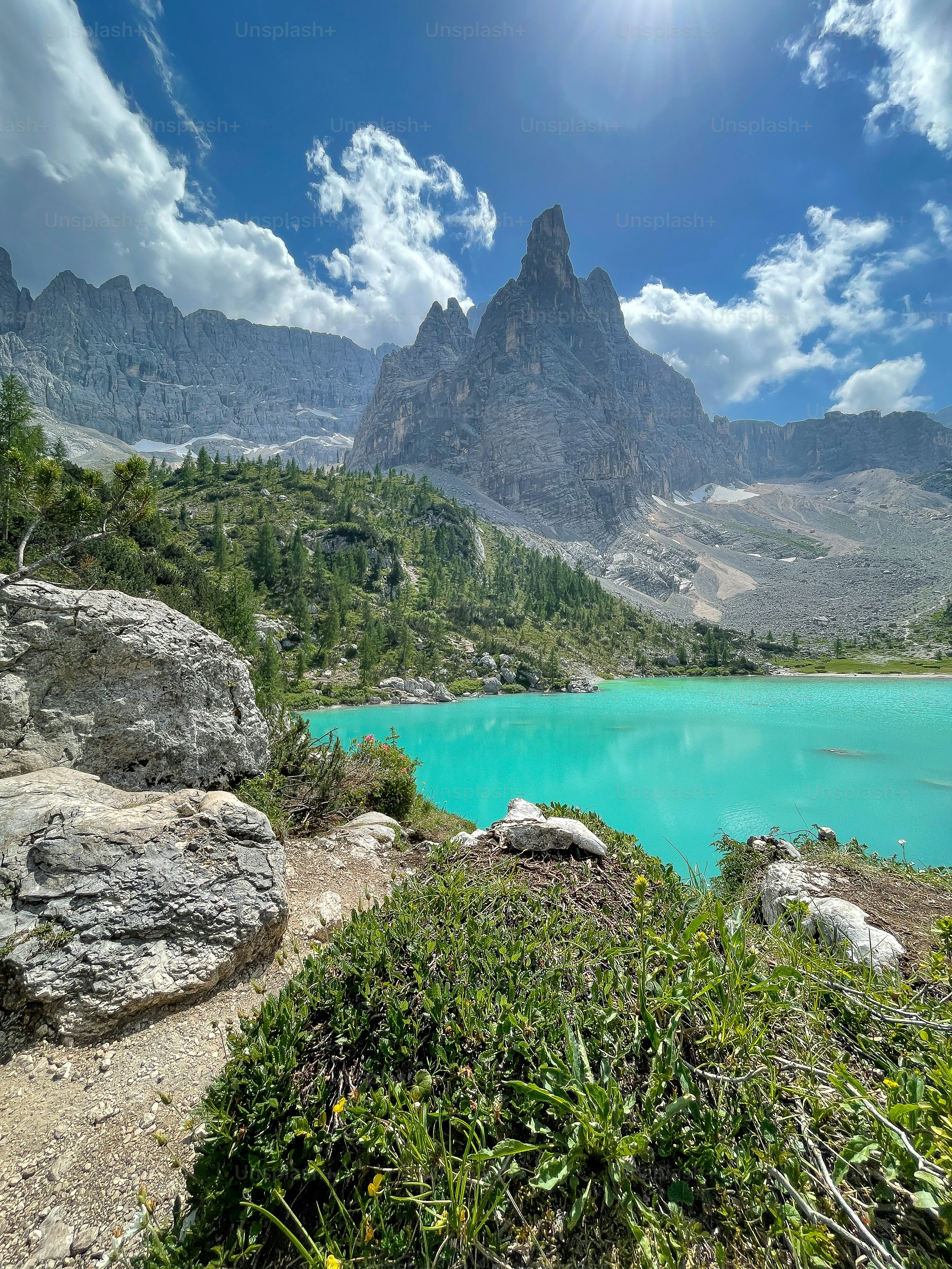 a blue lake surrounded by mountains under a blue sky